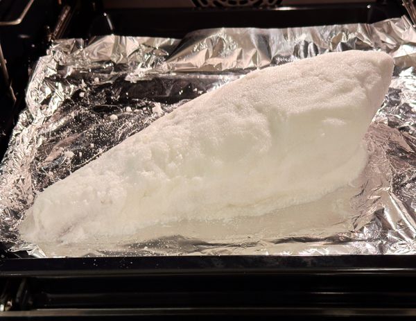 烤盤上鋪錫箔紙 ，先鋪一層鹽巴，再放上魚，再用剩下的鹽將魚整個裹住
