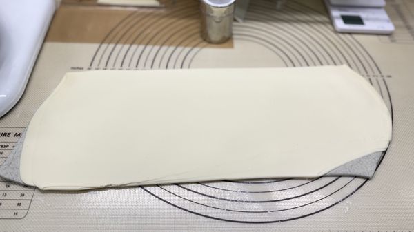 黑芝麻麵皮上先噴水抹開，再放上原味麵皮


💡💡💡麵糰打完後一定要經過排氣的步驟，使用壓麵機排氣是最省力省時的方法之一，使用萬能的雙手或桿麵棍來排氣也可以，比較適合少量製作，最後的結果就是麵糰一定要光滑平整無氣泡。