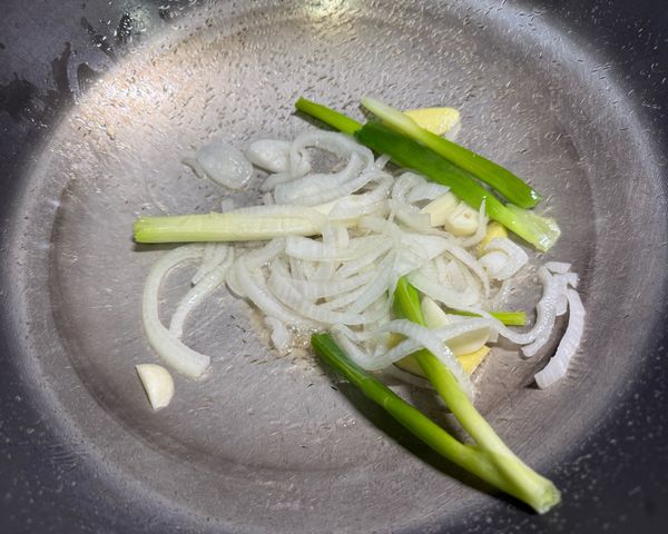 熱油後加入洋蔥、蒜、薑和蔥段炒香。
