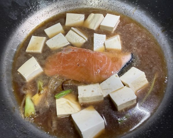 加入清水和切好的豆腐，大火燒開後，蓋上鍋蓋，轉中小火煮約10-15分鐘。