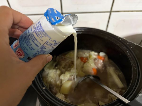 入乳製品，倒入100ml的牛奶，稍微攪拌，使米飯呈現微乳香，湯汁更濃郁。