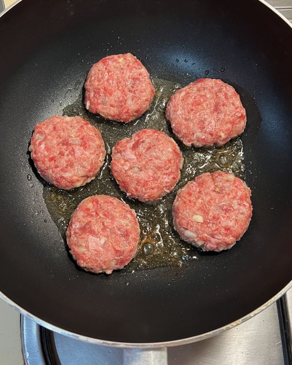 平底鍋中加入無鹽奶油與食用油小火加熱。
放入漢堡肉後，輕輕壓扁。
煎至兩面上色後取出備用。