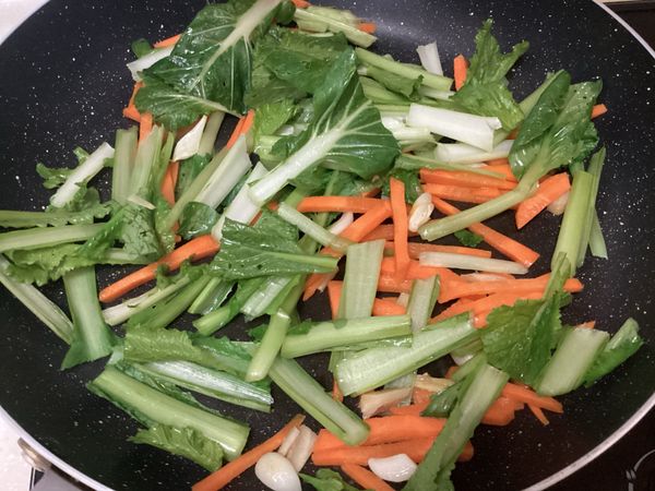 加入黑葉白菜的梗一起拌炒，等待炒軟後就可以加入葉子