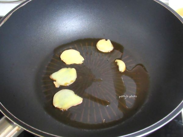 先煮麻油酒飯。平底鍋內倒入麻油，開小火，撒入1/4小匙鹽，放入薑片爆香。