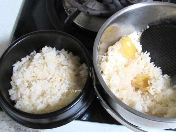 盛一碗煮好的麻油酒飯至砂鍋內，再擺進配菜，放上爐子煮。