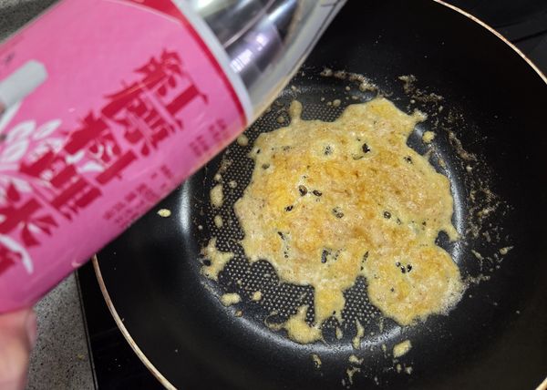 鍋中一匙油放入鹹蛋黃炒至起泡，
加入米酒去腥提味增加香氣