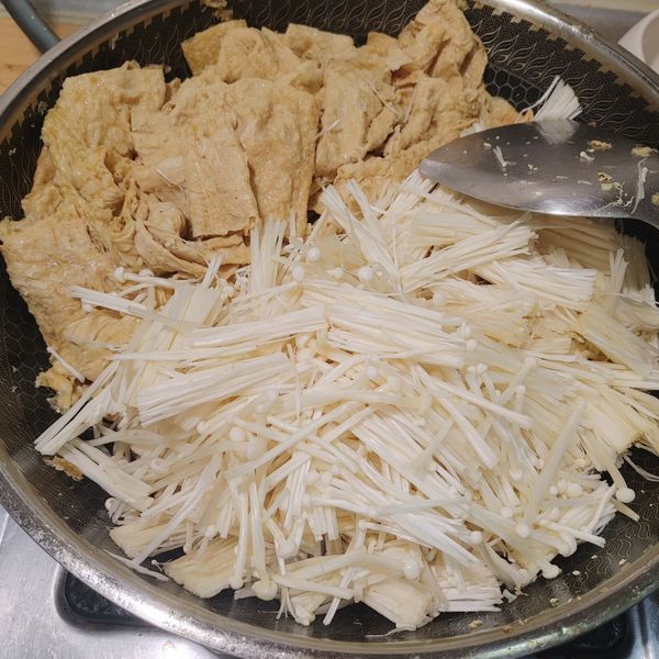 川燙好的豆皮加金針菇和薑片調料一起煮。
