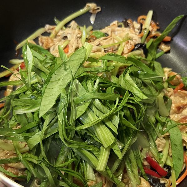 加入青江菜葉絲炒兩下即可關火，讓餘溫將葉子部分悶熟，完成