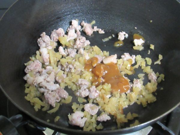 熱油鍋，放入絞肉、榨菜，拌炒一下，再加入調味料。