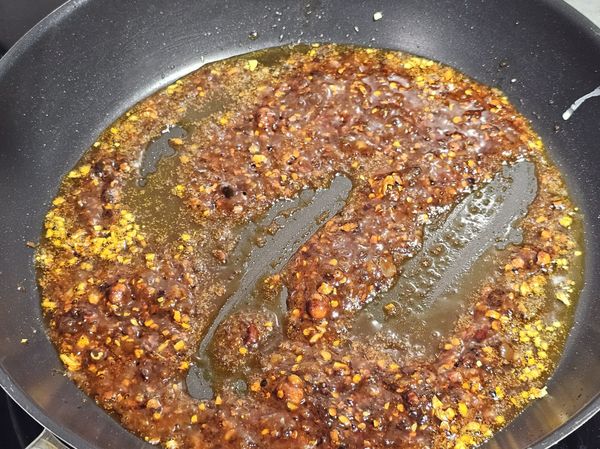 加入辣醬炒香，加入番茄醬與醬油，炒勻。