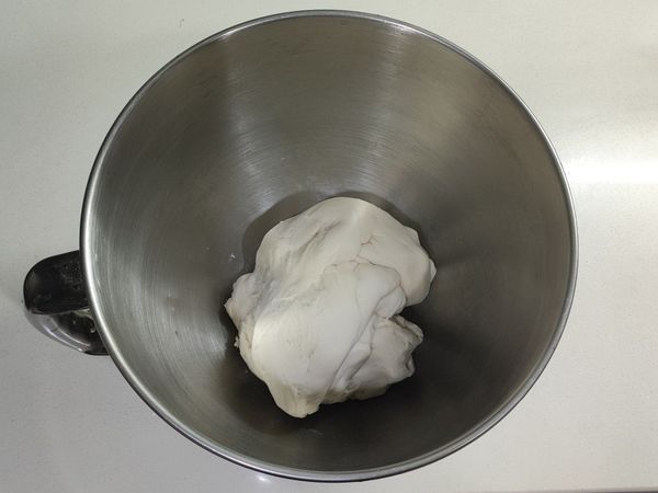 加入常溫水和鹽，攪拌至偏硬且光滑不沾黏的麵糰。