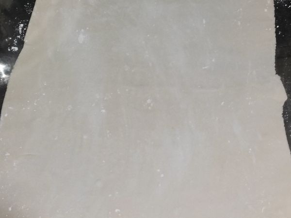 操作台面撒麵粉，然後將麵皮擀平至約0.2公分厚