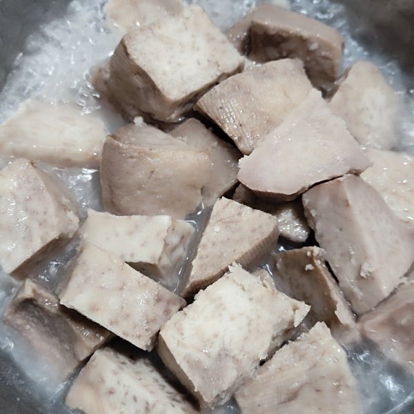 將蒸好的芋頭移入鍋內，開瓦斯爐加熱，加少量水分增加濕度。