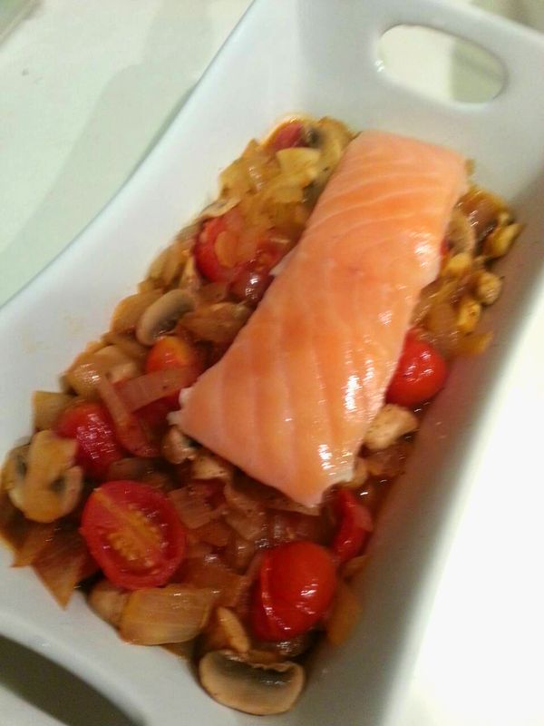 把拌炒好的料鋪在烤盤底部，將鮭魚放在上方。