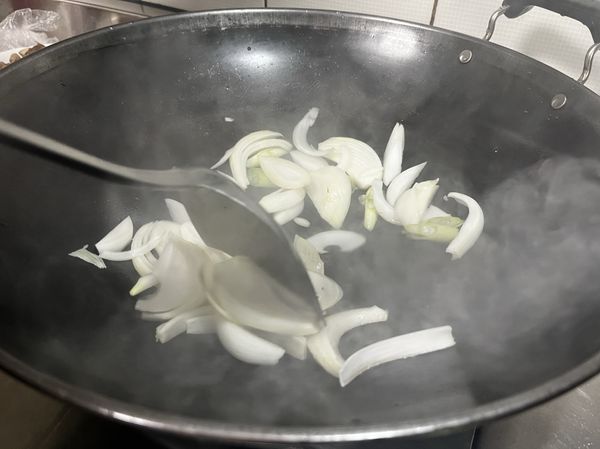 洋蔥切絲、蔥白斜切成段下鍋，用小火炒至變軟