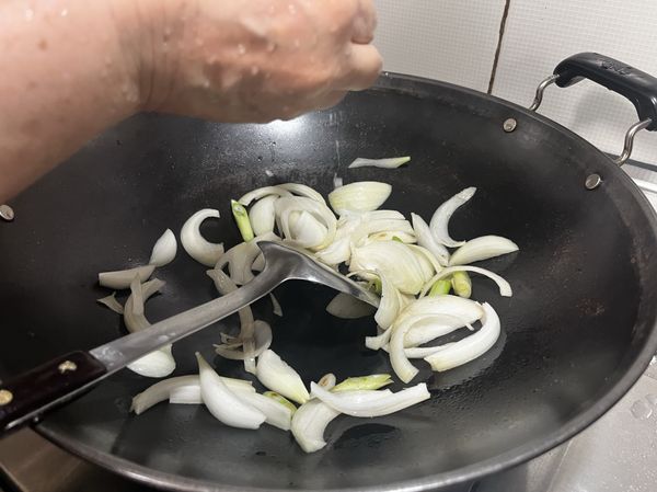 接著加少許鹽一起炒，若洋蔥不容易炒軟，可加一點米酒、一點水下去續炒，炒到軟