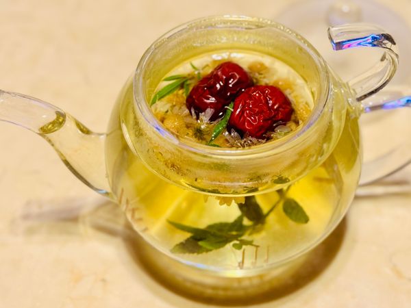剩餘的熱水泡花茶：菊花1把、紅棗2粒、芳香萬壽菊葉3片。