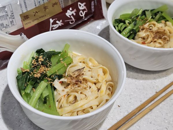 將煮好拌好醬料的統一好勁道寬版大麵與蔬菜盛入碗裡。灑上許油蔥酥，自家製拌麵美味上桌。