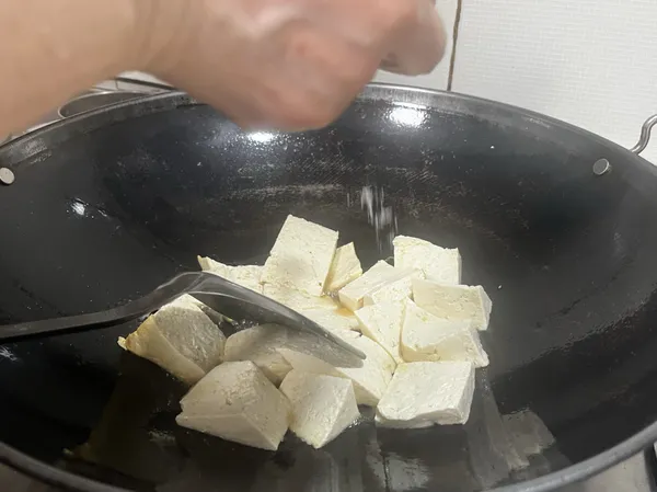 灑進一點鹽，並將豆腐煎到兩面金黃焦香