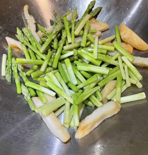 熱鍋，加入一匙橄欖油，用小火先將甜不辣煎一下，加入蘆筍均勻拌炒。