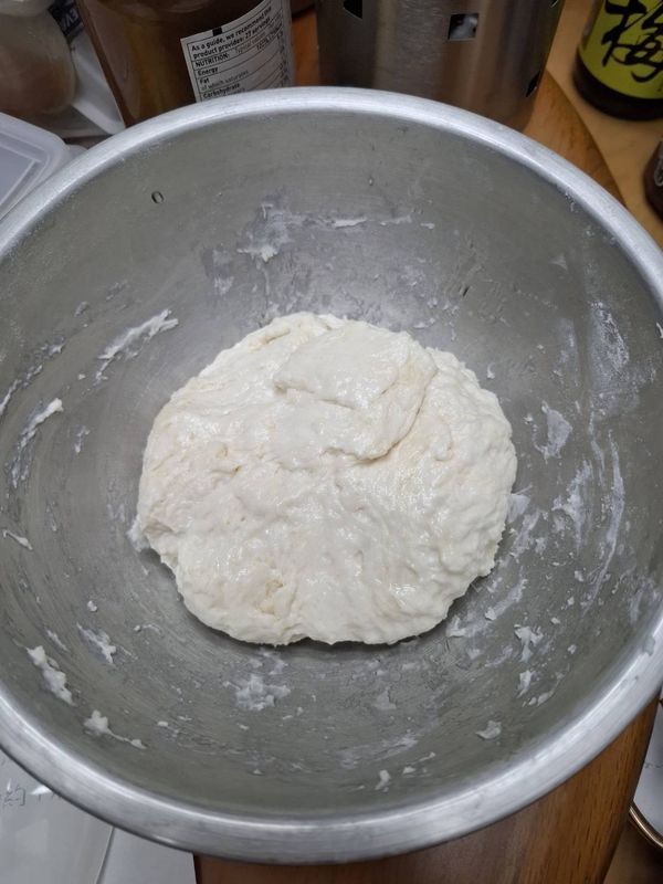 將麵糰的所有材料包含剛剛混合的酵母糖水攪拌在一起，成團後表面抹上少許油，蓋上布放置15分鐘
