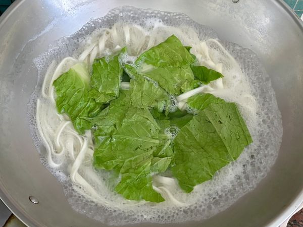 加入青菜，續煮1分鐘，撈起瀝乾放入碗中