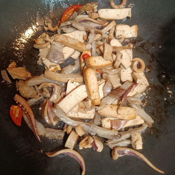接著放入蒜蓉、辣椒、肉絲、魷魚炒香，在放入所有的調味料，拌炒均勻