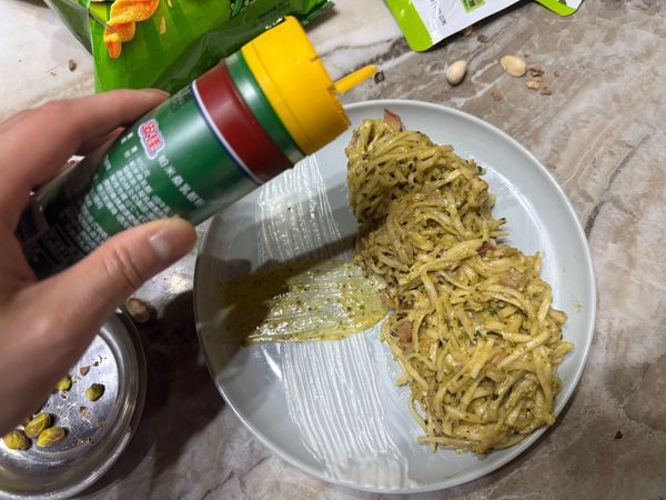 盛盤裝飾，撒上起司粉、開心果碎及可樂果