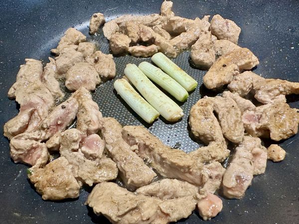 肉炒至略變白鎖住水分後把蔥白段放進來一起煸炒出香氣。