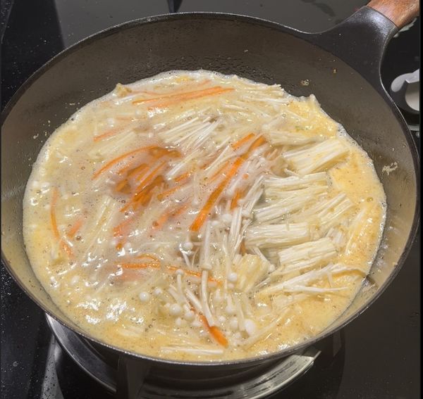 加水，加耐煮的紅蘿蔔、金針菇，蓋鍋煮出香氣