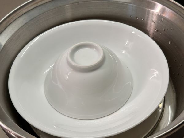將碗放在盤上，放電鍋準備蒸雞腿肉

（這樣蒸的時候，雞汁跟雞油會鎖在碗內！雞肉蒸起來不油更清爽）