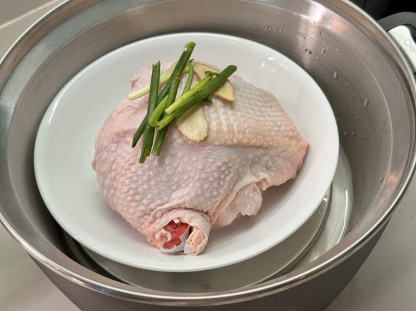 將醃好的雞腿肉放在碗上，上面再放幾片薑跟蔥段，外鍋用1杯半水蒸，跳起後不掀蓋再悶 10 分鐘！

（雞肉熟透軟嫩的重點）