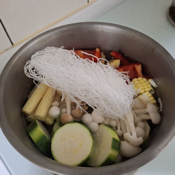 水滾後加入冬粉與火鍋肉片，繼續煮至再次沸騰。