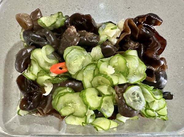 把泡涼的黑木耳也加進來，小黃瓜片中，再加上蒜末跟去籽的辣椒片，淋上日常當保健飲的野櫻莓果醋蓋上密封盒蓋子放冷藏浸泡。