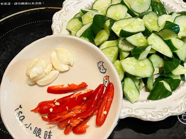 小黃瓜洗淨、滾刀切塊，辣椒切片，蒜頭拍扁。