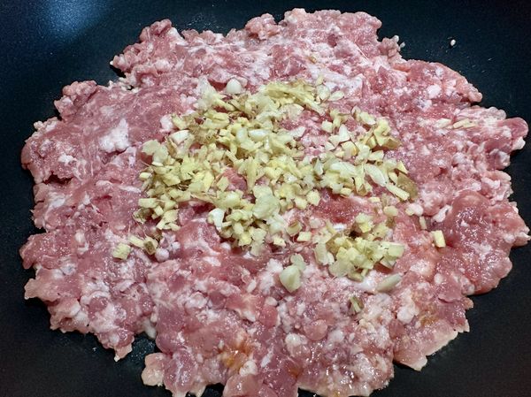 ●鍋小火不用放油，將(豬絞肉)均勻鋪平上面撒上(薑蒜末)小火，蓋鍋煎5分鐘。