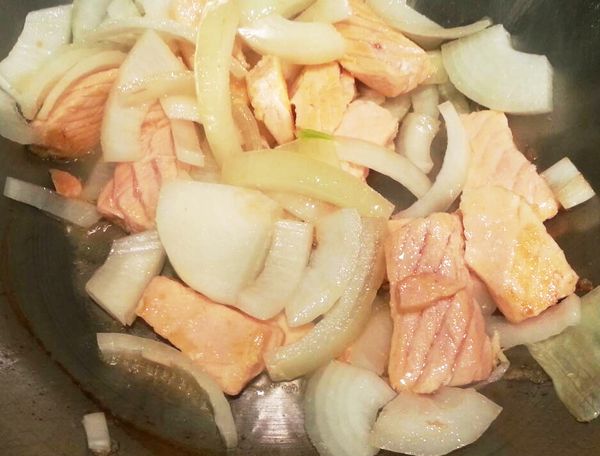 熱鍋熱油煎鮭魚，等鮭魚表面變色再加入洋蔥拌炒。