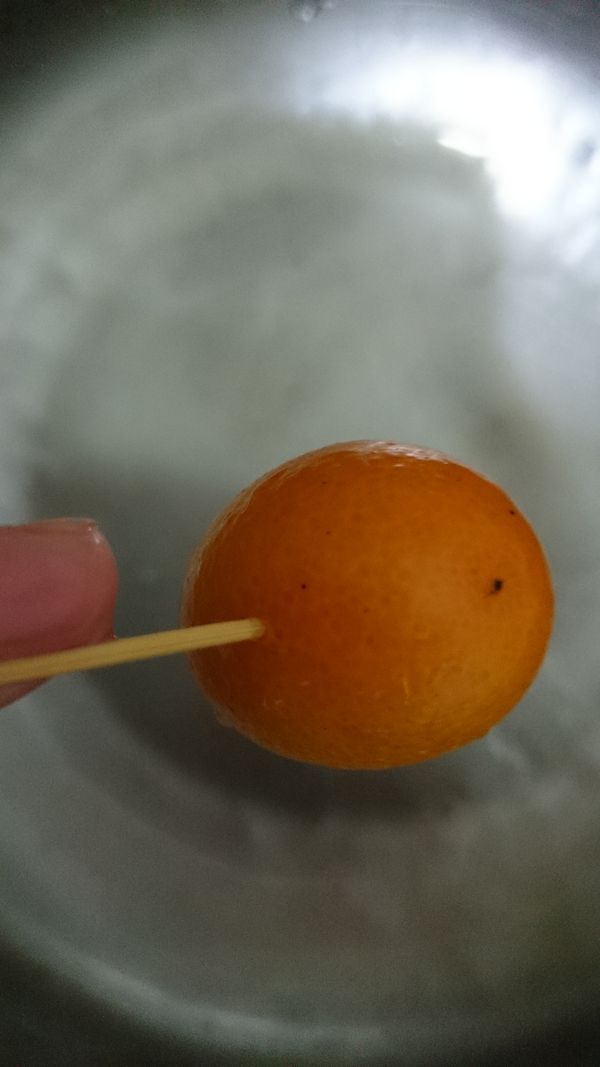 用牙籤刺金棗 ，多刺一點 ，煮的時候才不會裂開