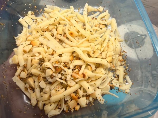 準備一個小碗，把剛剛放涼的夏威夷豆碎、義式綜合香料、起司絲（或起司粉），加上少許的鹽巴和黑胡椒，全部倒在一起攪拌均勻。這就是我們今天雞肉捲裡面香噴噴的靈魂內餡啦！