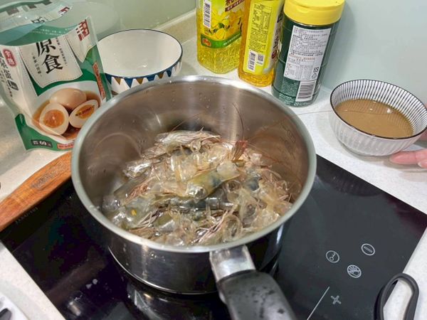 切碎其中一隻瓜地馬拉產地 白蝦，並和其餘蝦殼一起放入鍋中，下入 1 湯匙食用油，準備用來熬煮蝦湯。