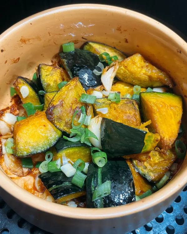 👨🏻‍🍳做法：
❶南瓜去籽切小塊
❷南瓜加碎碎和所有調味料拌勻
❸氣炸鍋180度烤10分鐘後翻拌均勻再續烤5分鐘，最後撒上蔥花即可
