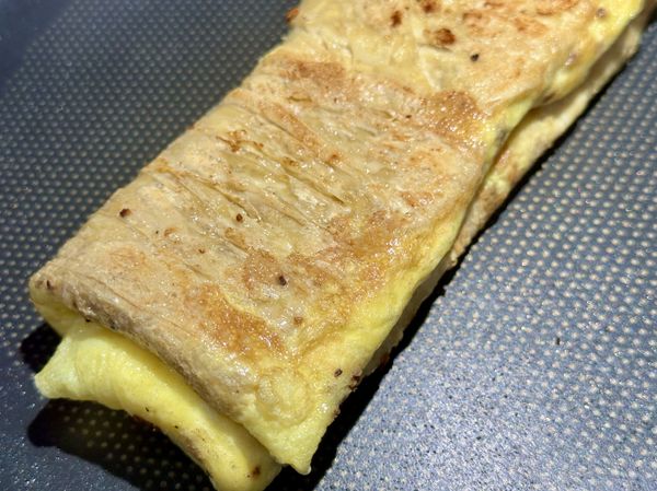 豆皮蛋餅翻摺成蛋捲後兩面煎金黃，就完成啦。
從開始煎豆包時按下手機碼錶計時，共計8分鐘。
