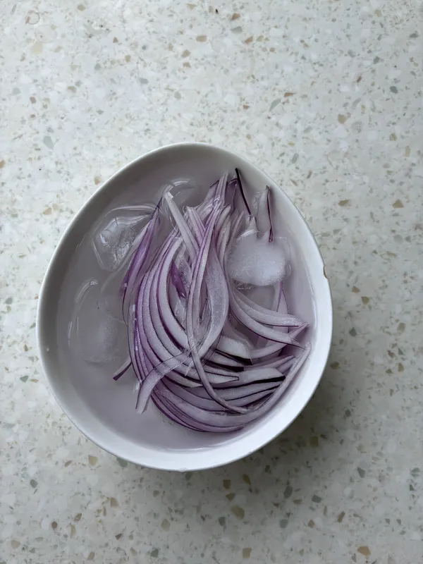 紫洋蔥切絲泡一下冰水，吃起來才不會太辣。