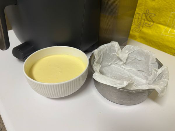 將蛋糕體倒入模具
若有使用烘焙紙，可以先將烘焙紙揉成小拳頭大小再鋪放於模具，避免烘焙紙後續被捲起來
放入模具後可以輕敲桌面兩下，讓蛋糕體更密實