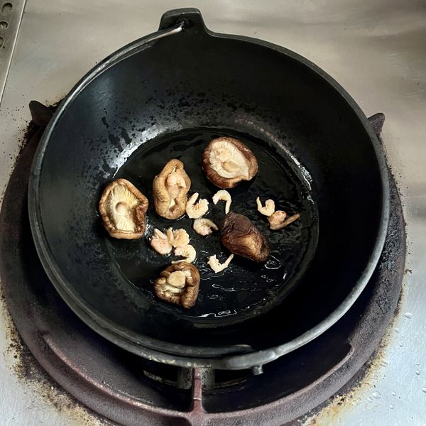 用一個可以炒的湯鍋（如鑄鐵鍋），下部份油放入香菇、蝦米炒出香味後，再加入豬肉、魷魚炒出香氣。