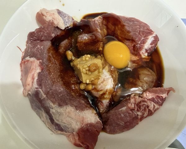 取一容器，將梅花肉與醃肉調料充分混合