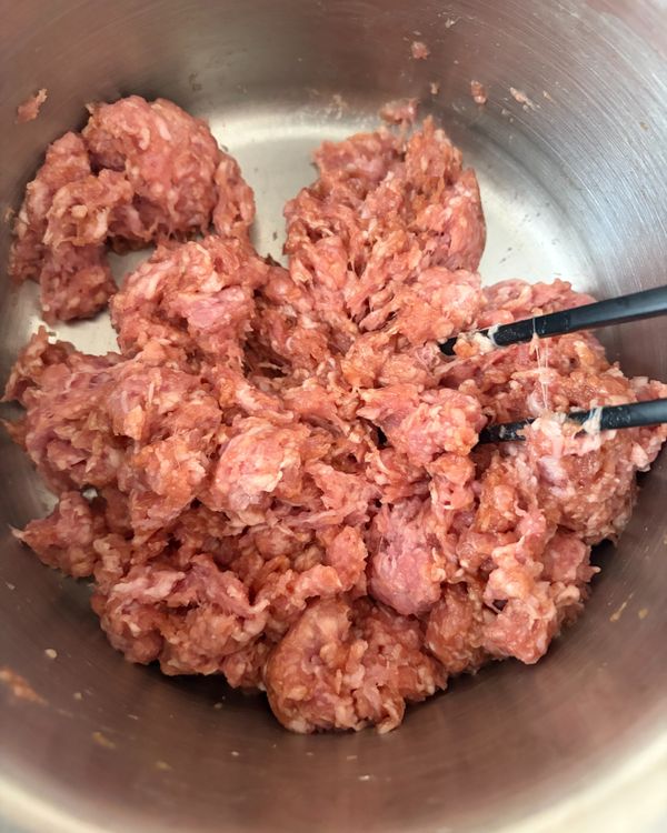 調製豬肉餡　
豬絞肉放入較大的碗中，加入除了麻油和高湯以外的所有調味料，用筷子攪拌均勻。