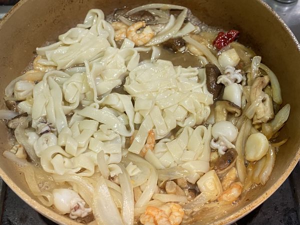 嗆入米酒後加入板條、水、醬油。