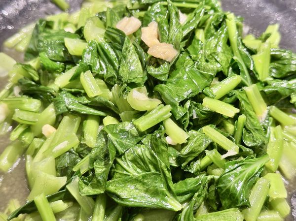 菜梗從生綠變略輕透時再把小松菜葉放進來翻拌，菜葉變深綠就完成啦。