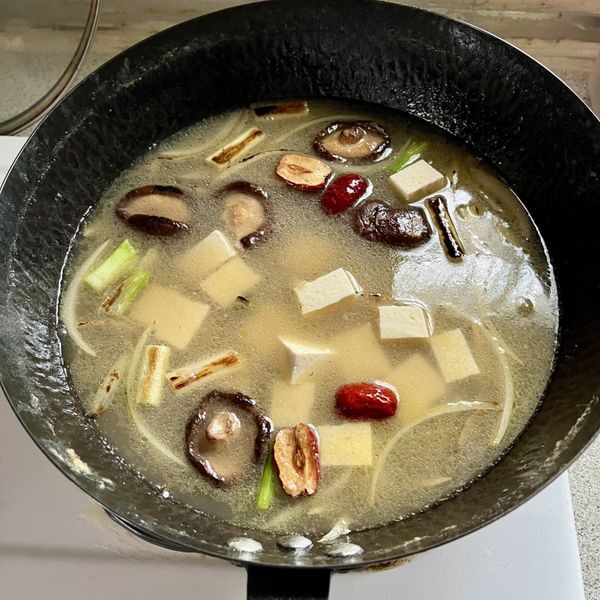 加入適量浸泡過雞的高湯、豆腐、紅棗，開大火煮滾後，轉小火煮約5分鐘，加入適量鹽巴調味，再加入枸杞煮3分鐘即成。蔥花是在盛湯時灑上增加。